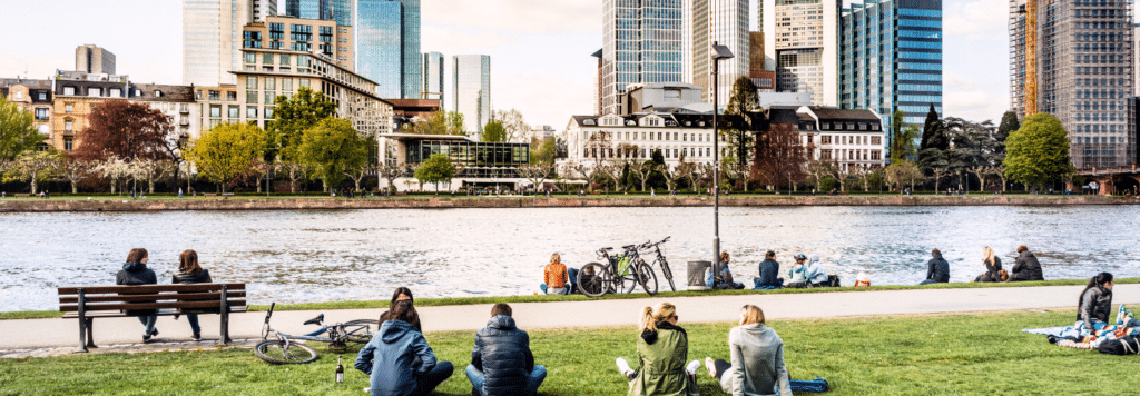 Menschen am Mainufer vor der Skyline Frankfurts