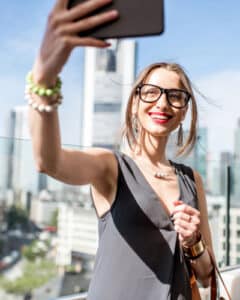 Frau macht Selfie im Sommer vor der Frankfurter Skyline